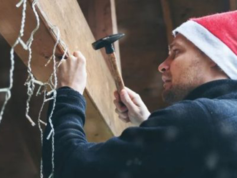 man decorating house with lights